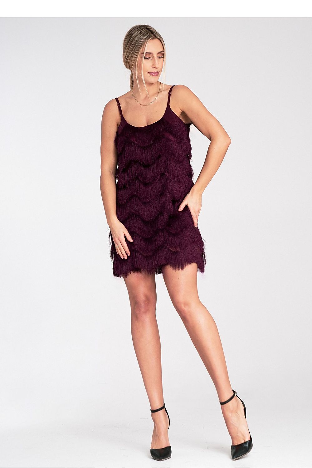 Woman wearing a purple fringe dress on a white background