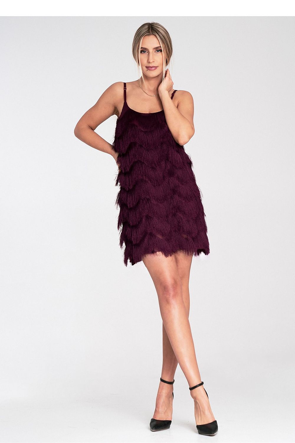 Woman wearing a burgundy feathered dress on a white background