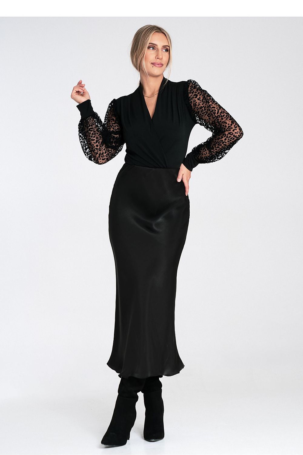 Woman wearing a black dress with lace sleeves on a white background