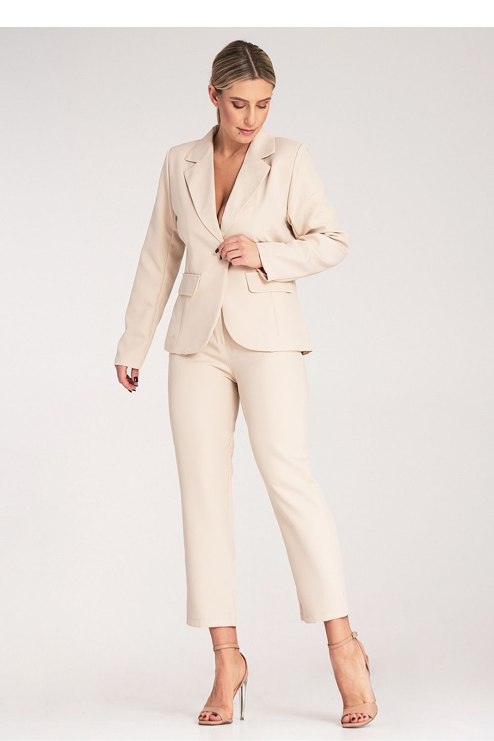 Woman wearing a beige suit on a white background