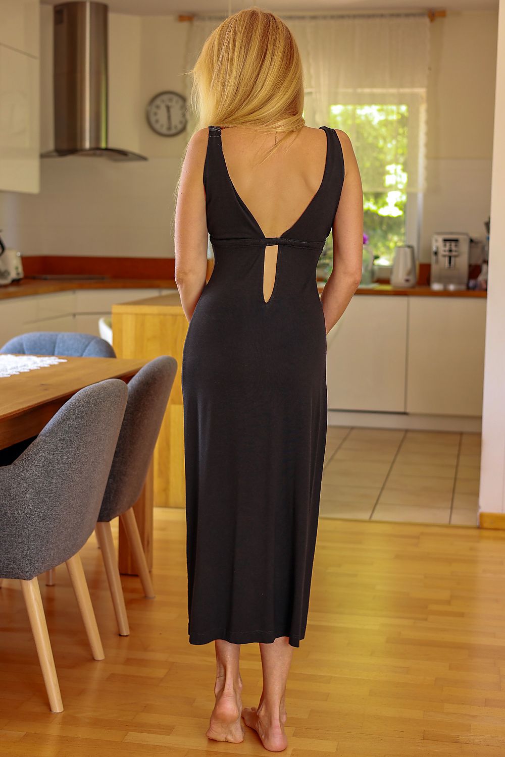 Woman in a black dress standing in a kitchen