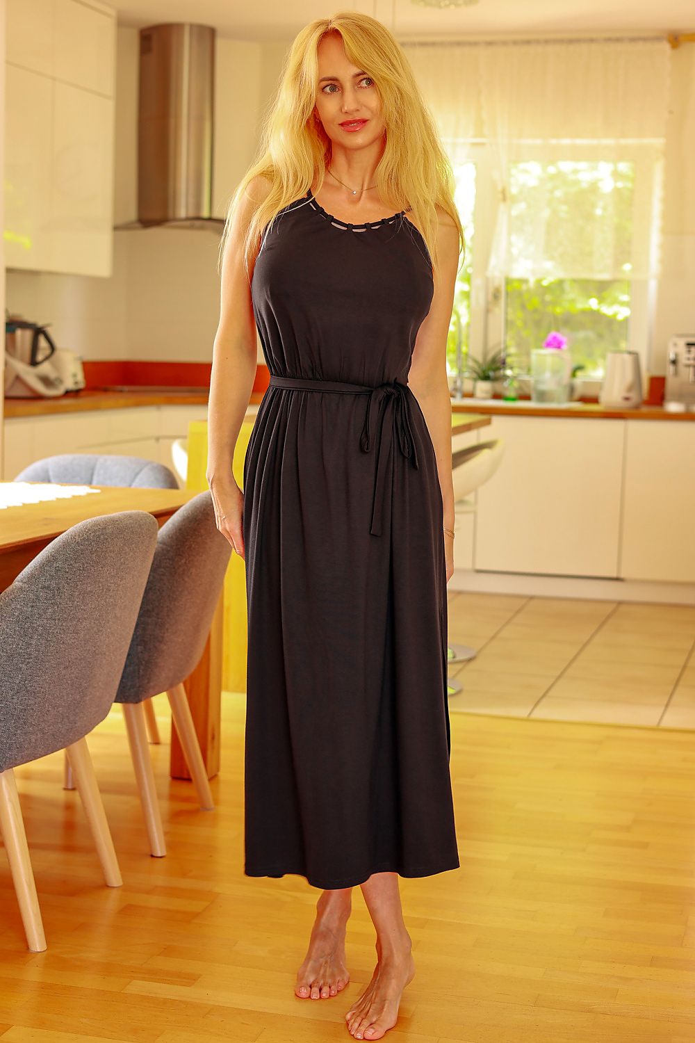 Woman in a black dress standing in a kitchen