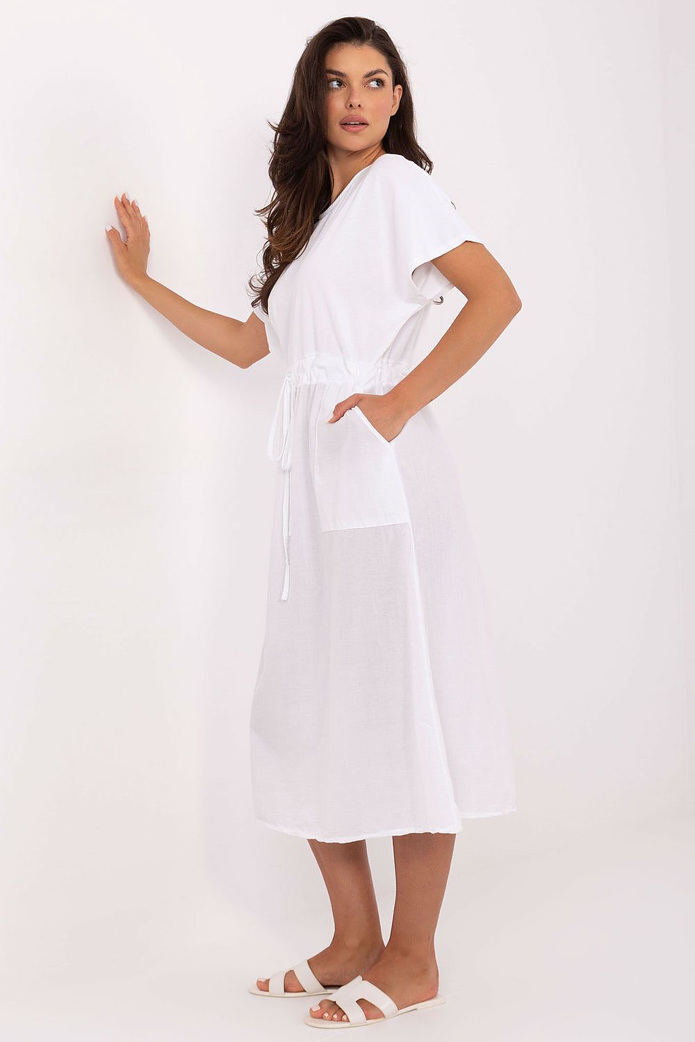 Woman wearing a white dress against a plain background