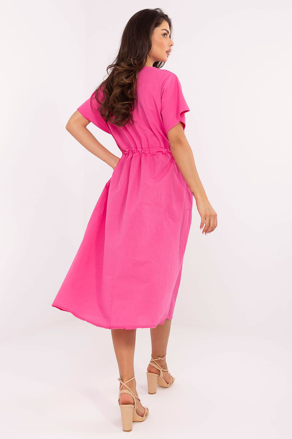 Woman wearing a bright pink dress on a white background