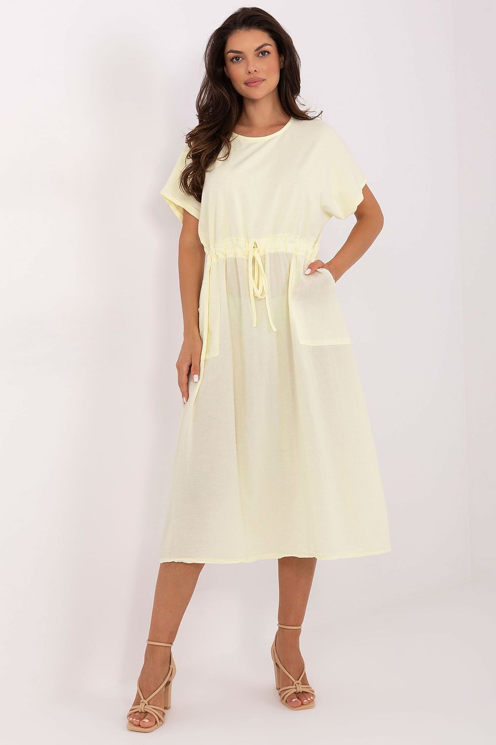Woman wearing a light yellow dress on a white background