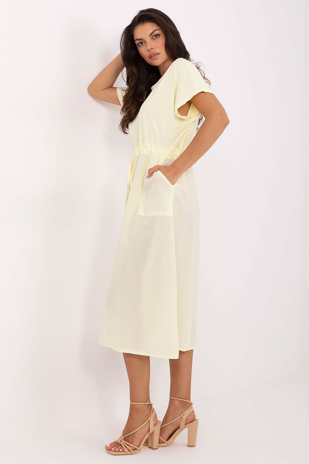 Woman wearing a light yellow dress against a white background