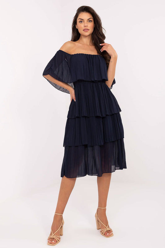 Woman wearing a navy off-shoulder layered dress on a white background
