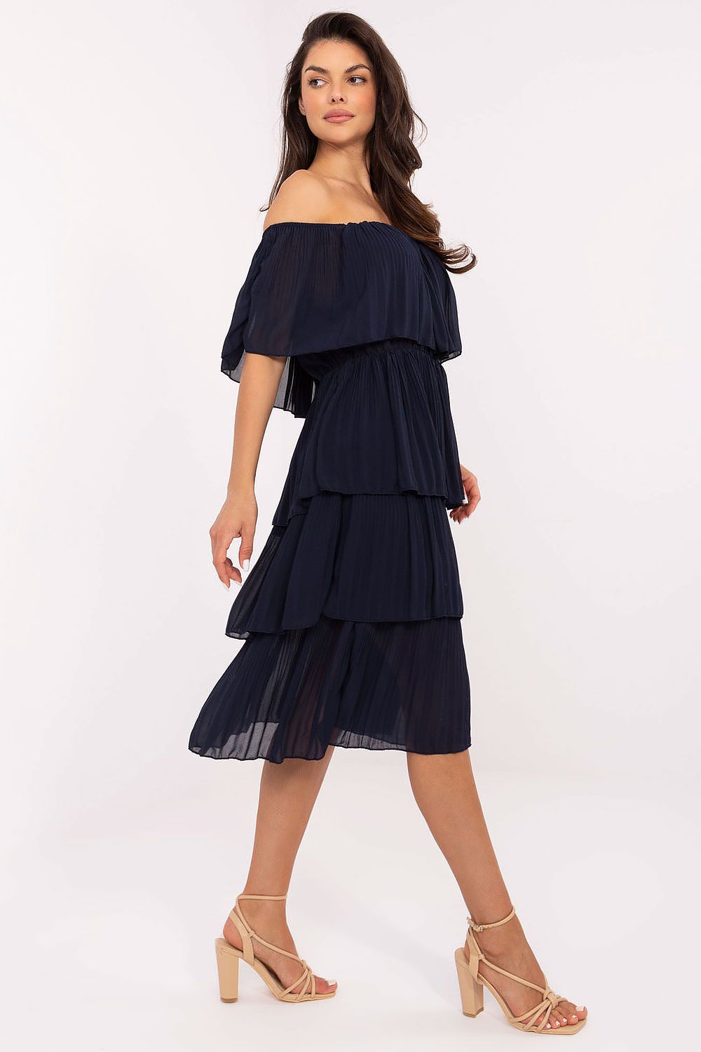 Woman wearing a navy off-shoulder dress on a white background