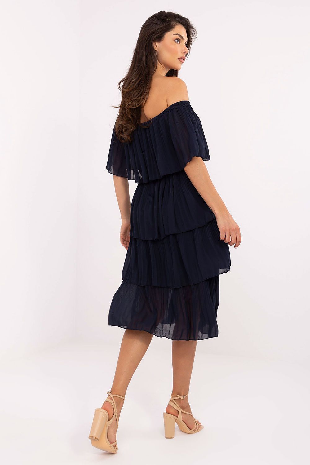 Woman wearing a navy off-shoulder dress on a white background