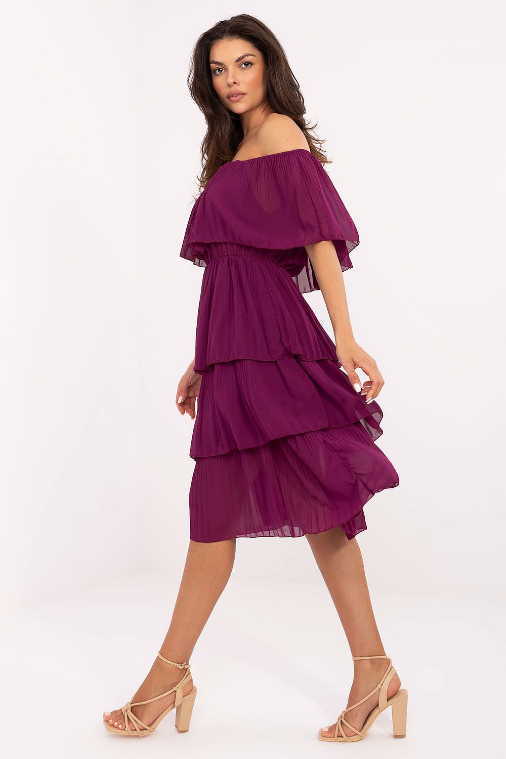 Woman wearing a purple off-shoulder dress on a white background
