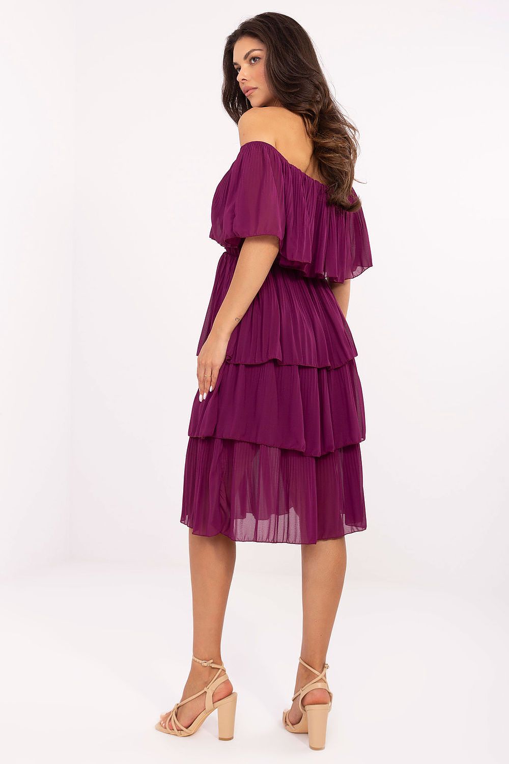 Woman wearing a purple off-shoulder dress on a white background
