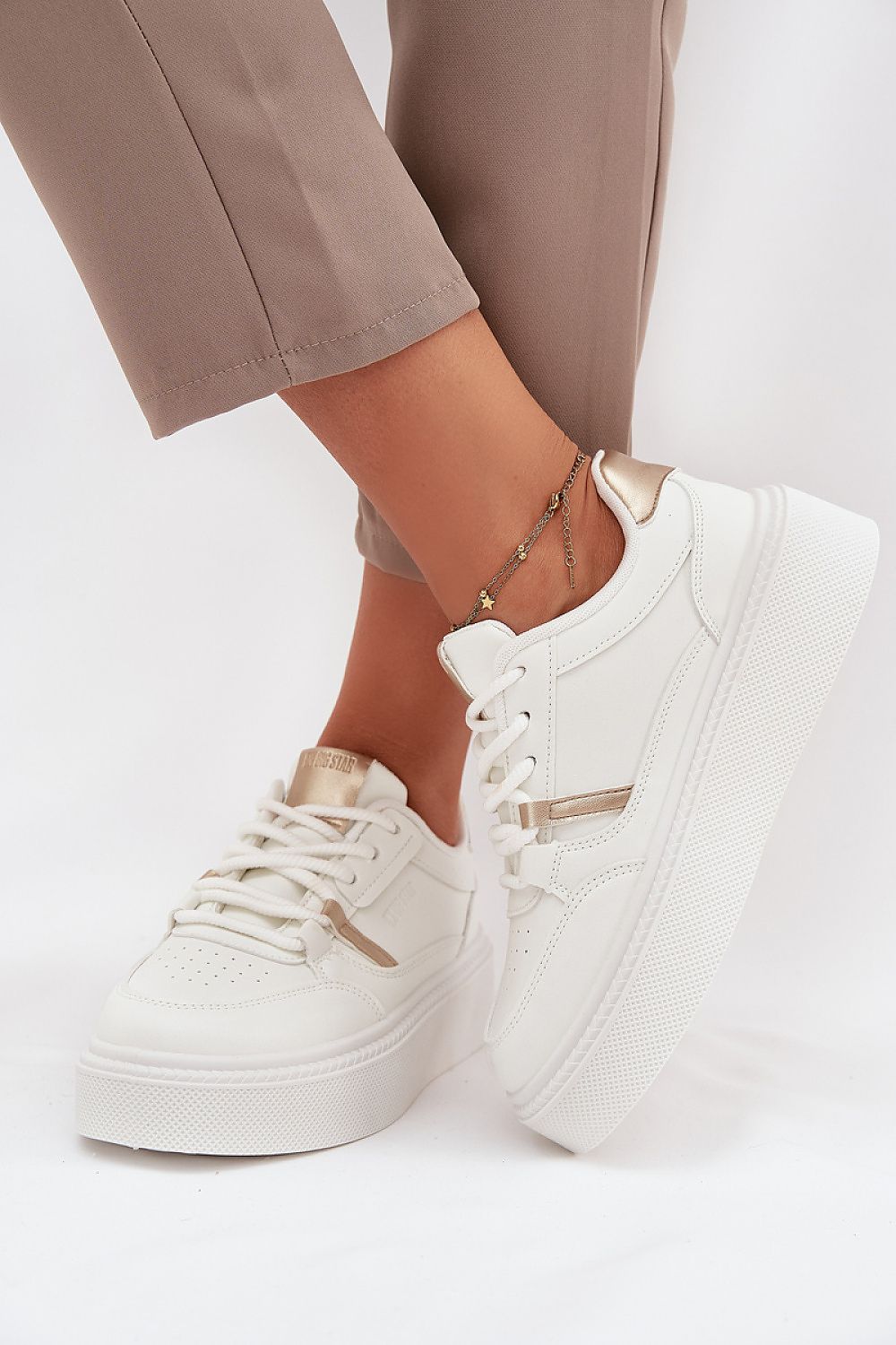 Side view – White laced women’s sneakers showing smooth texture.