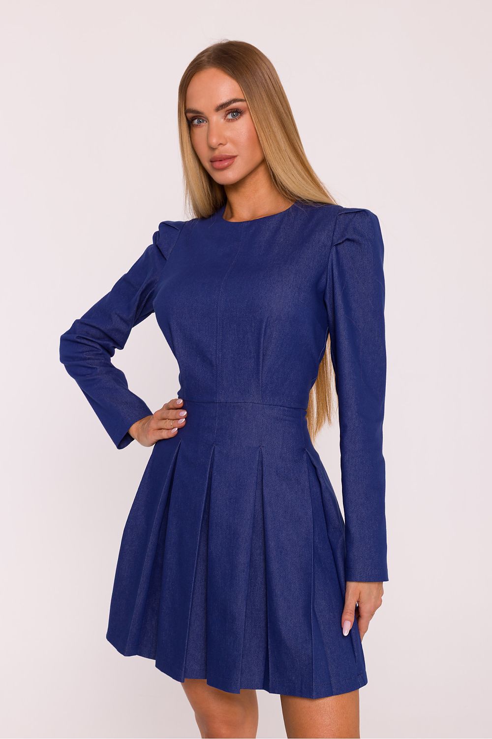 Woman wearing a blue dress against a white background