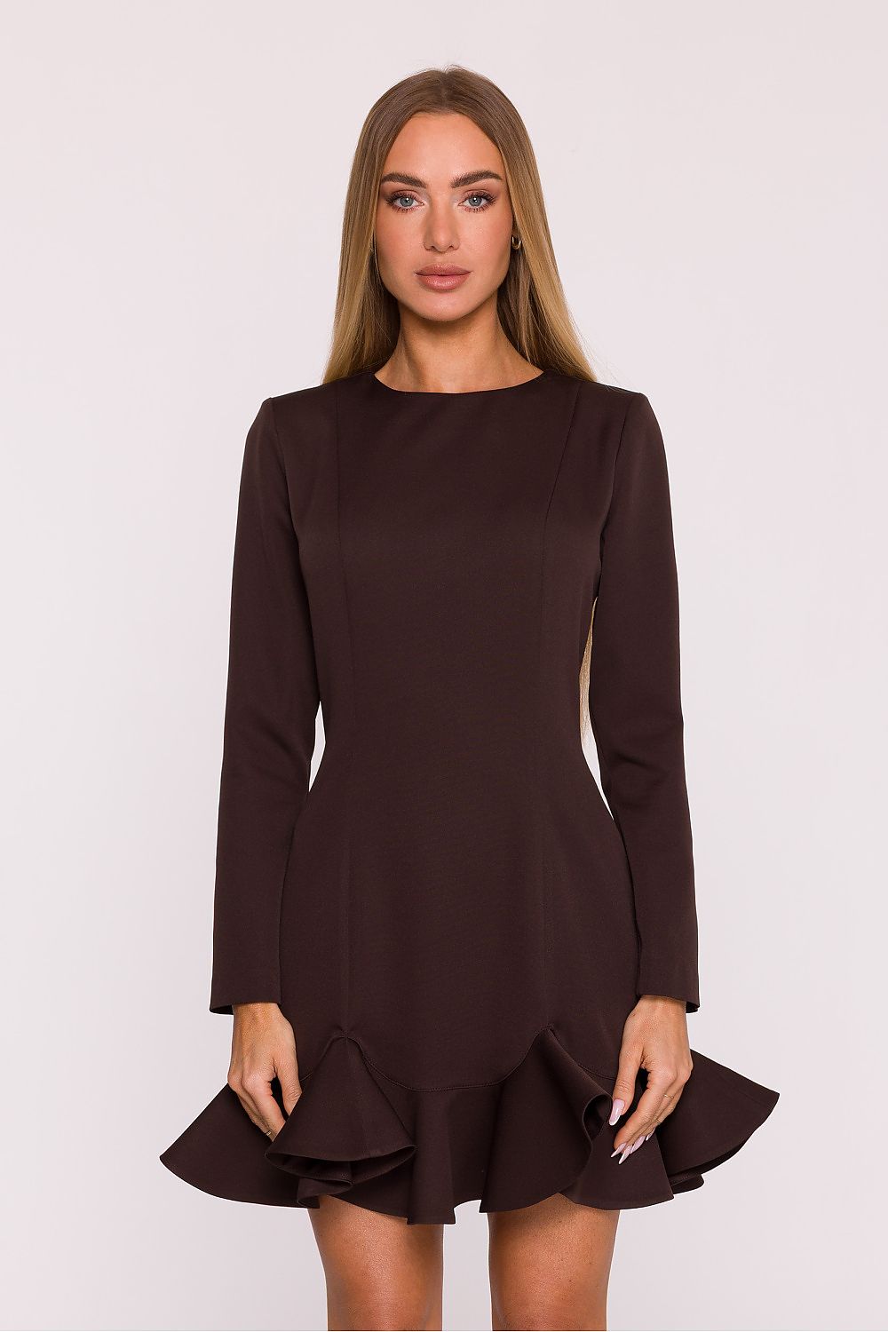 Woman wearing a brown dress with long sleeves on a white background