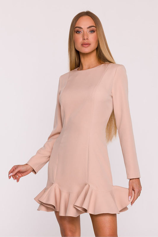 Woman wearing a beige dress with long sleeves on a white background