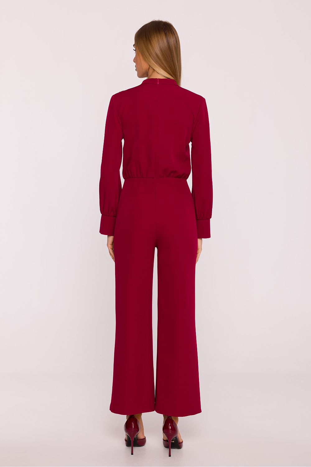 Woman wearing a red jumpsuit on a white background