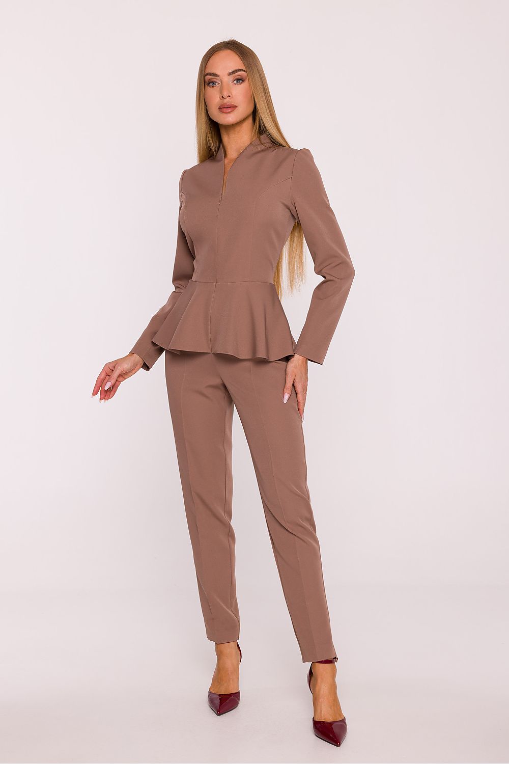 Woman wearing a brown peplum top and pants on a white background
