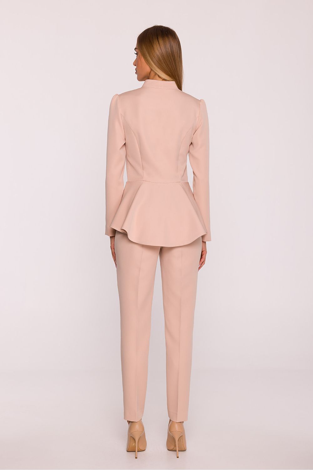 Woman wearing a light pink suit on a white background