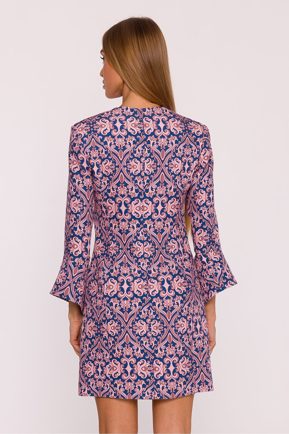 Woman wearing a patterned dress on a white background