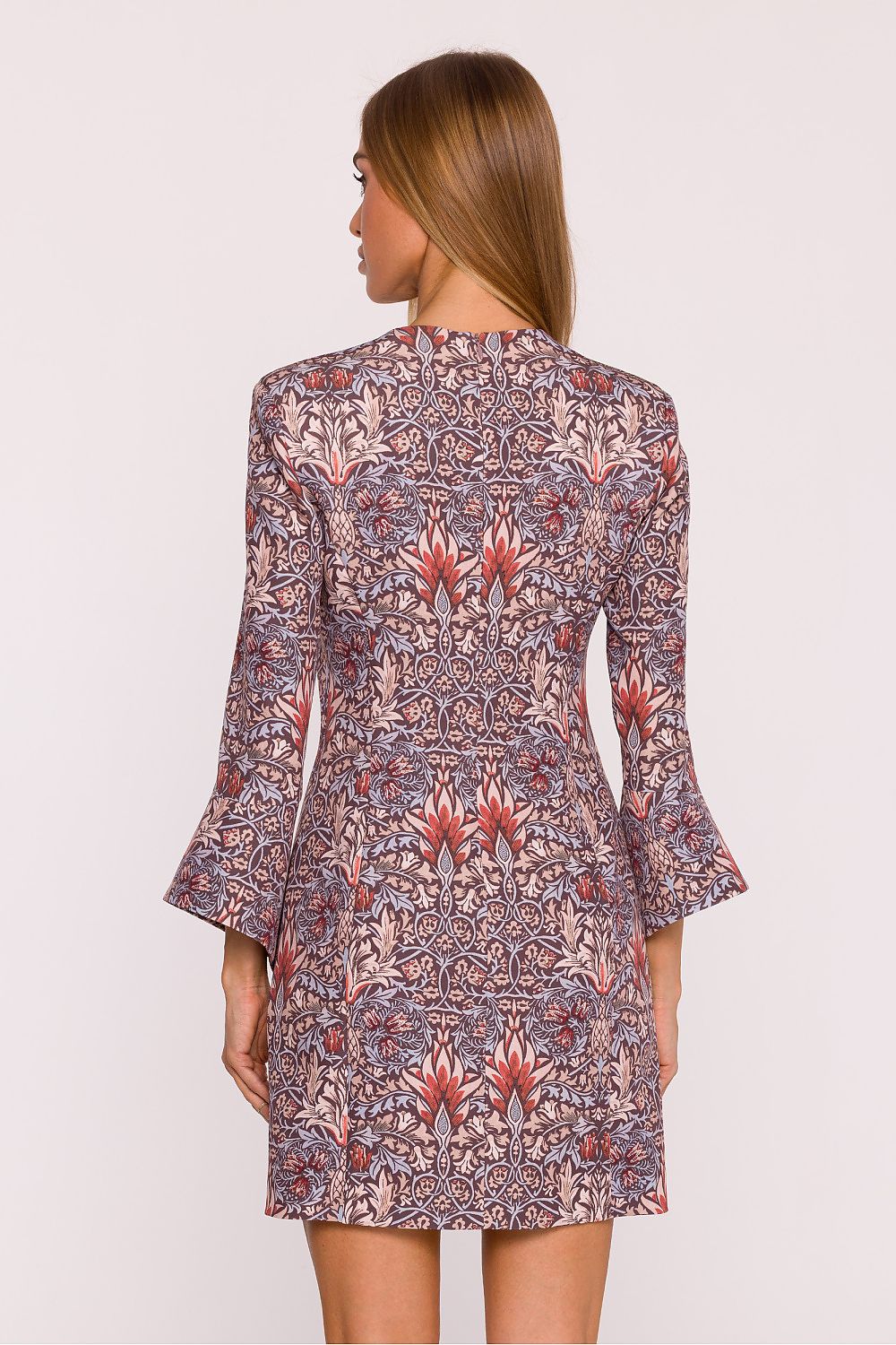 Woman wearing a patterned dress on a white background