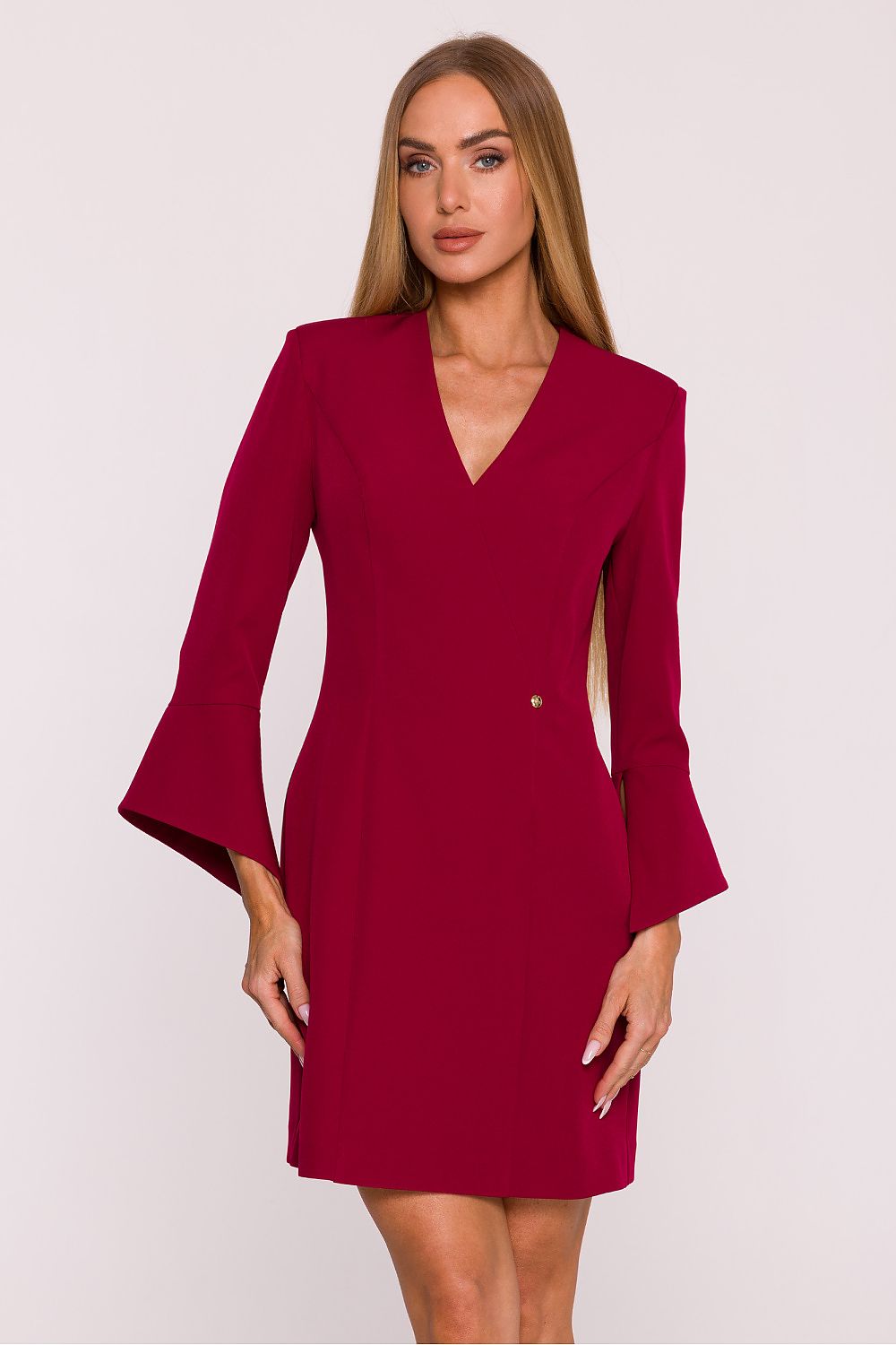 Woman wearing a burgundy dress with bell sleeves on a white background