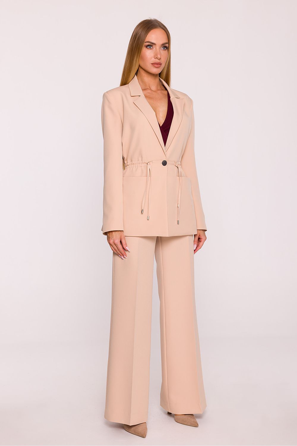 Woman wearing a beige suit on a white background