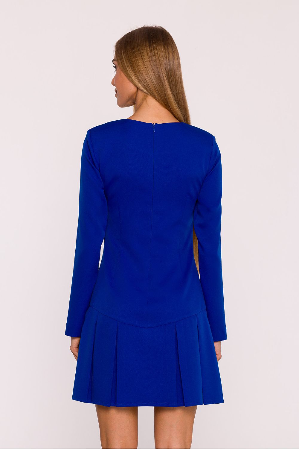 Woman wearing a blue dress with long sleeves on a white background