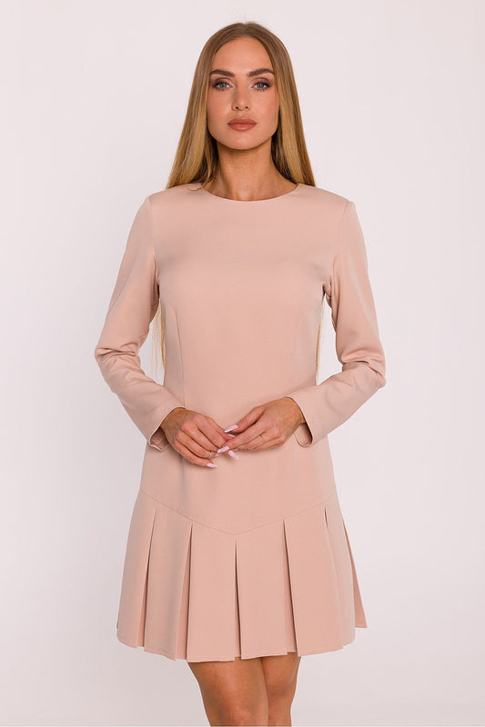 Woman wearing a light pink dress against a white background
