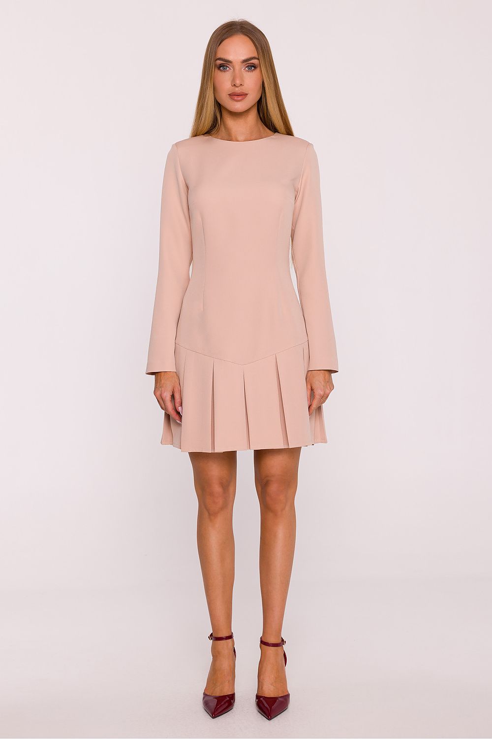 Woman wearing a light pink dress on a white background