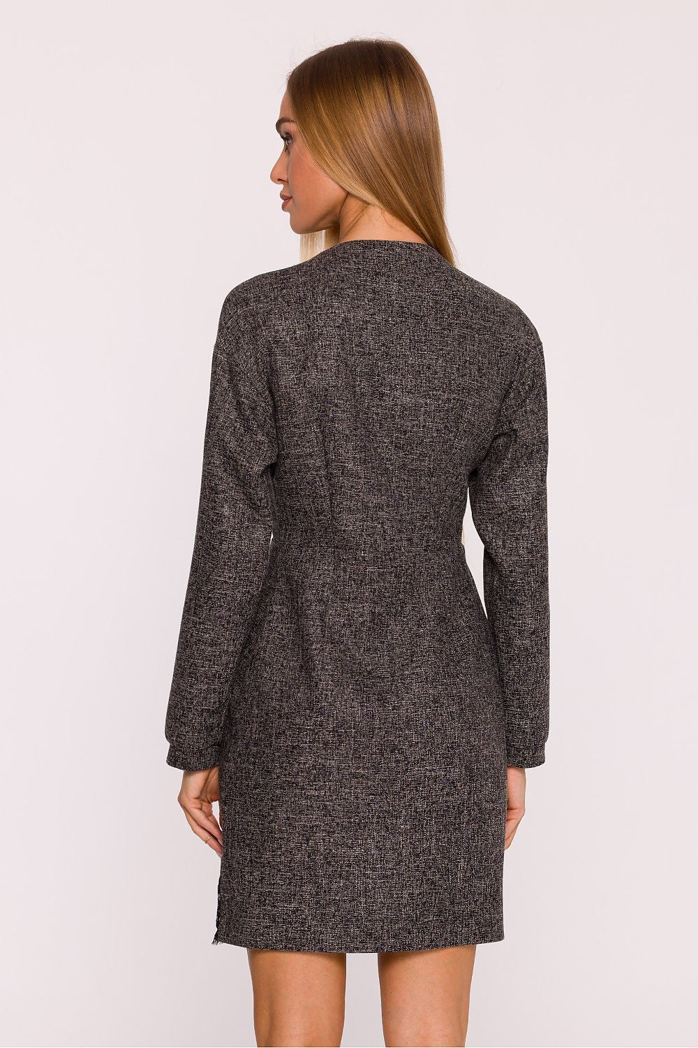 Woman wearing a gray textured dress against a white background