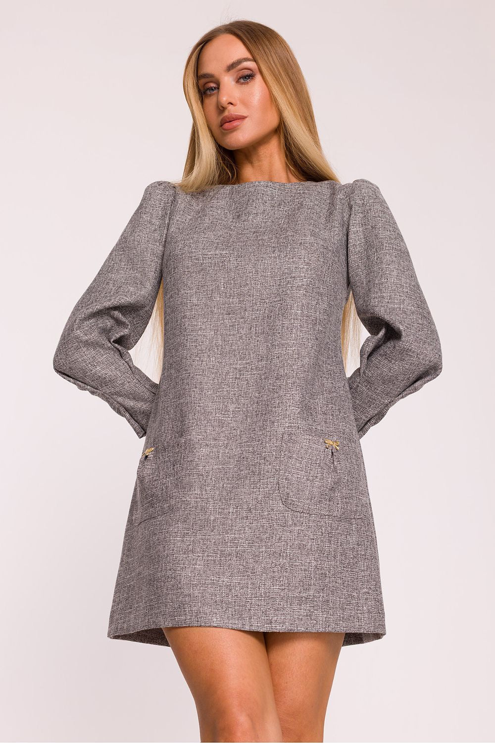Woman wearing a gray dress with long sleeves on a white background