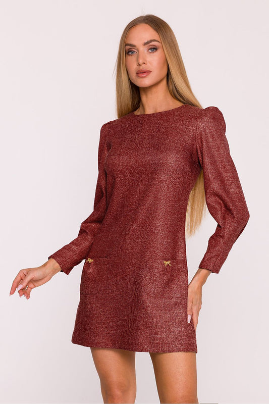 Woman wearing a maroon sweater dress against a white background