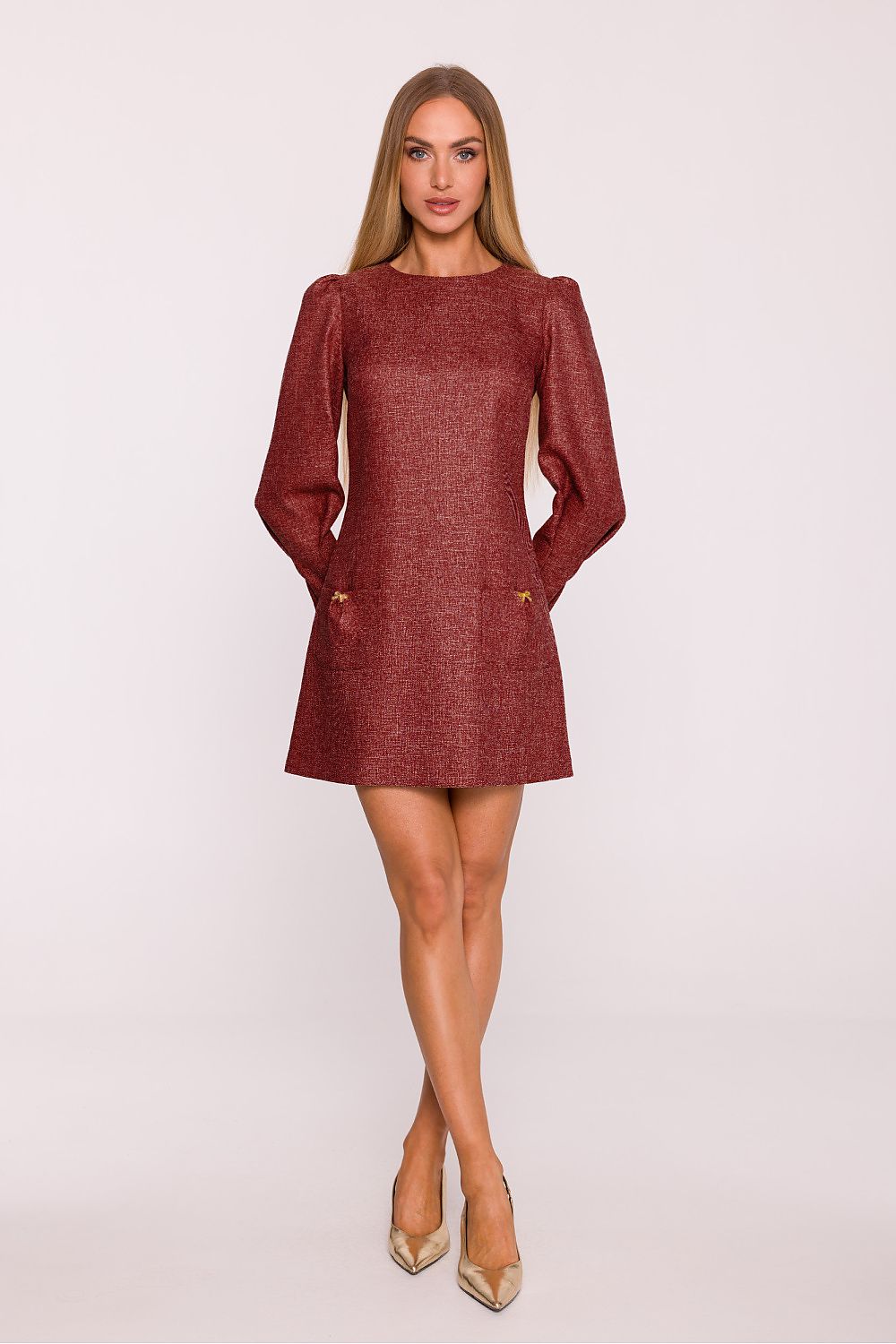 Woman wearing a burgundy dress with long sleeves on a white background