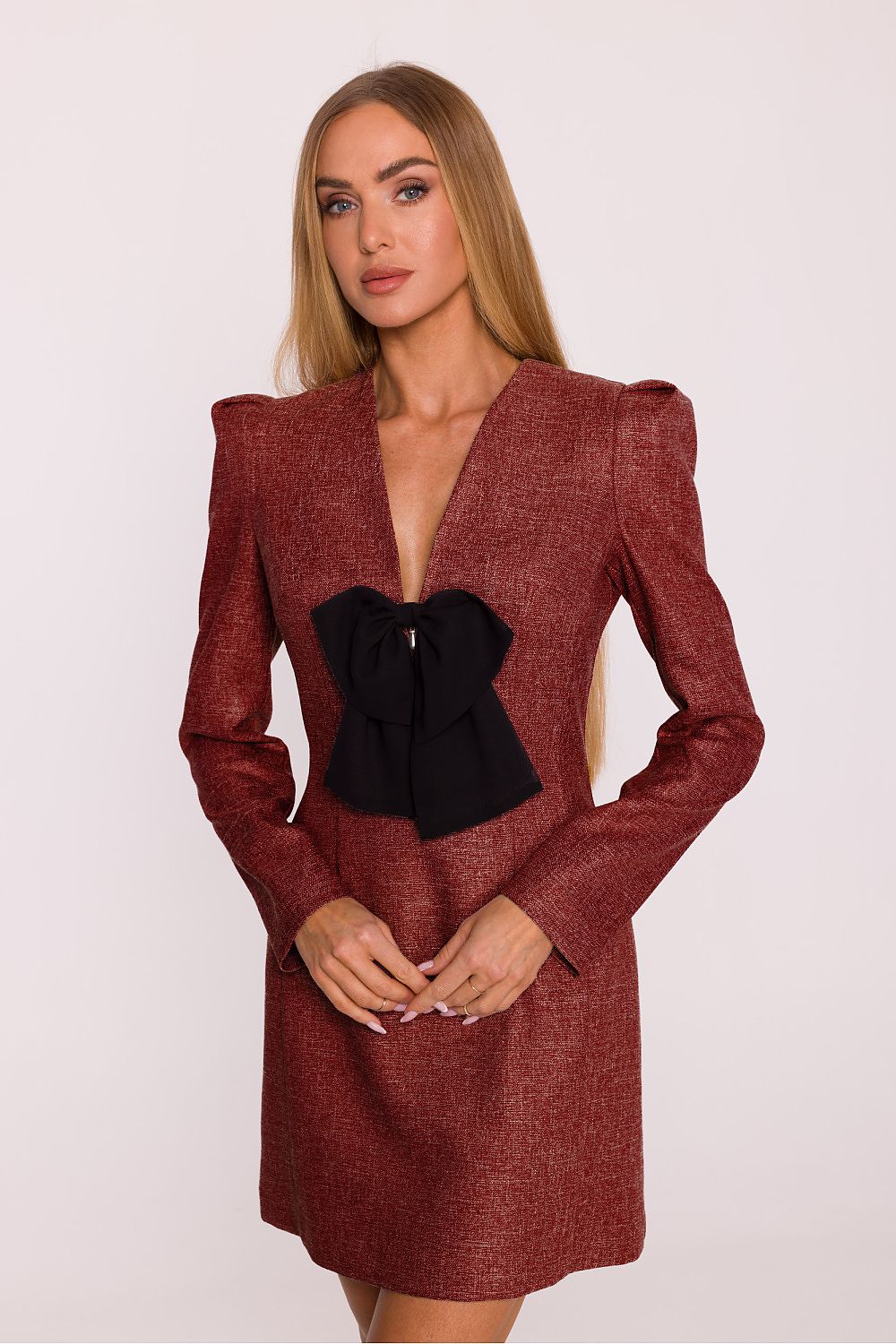 Woman wearing a red dress with a black bow on a white background