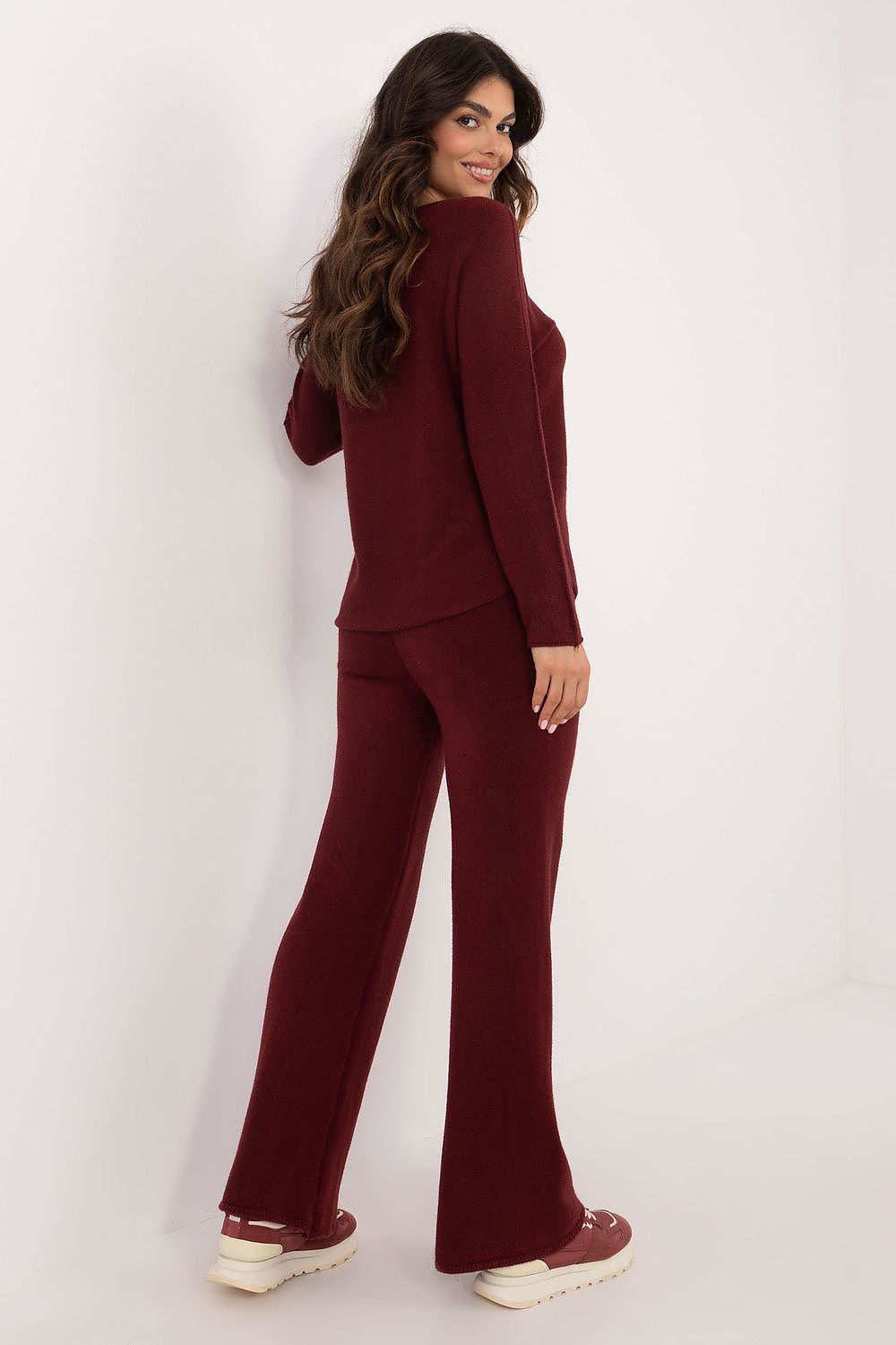 Back view of deep red women’s sweater and wide-leg pants set highlighting classic cut and modern silhouette.