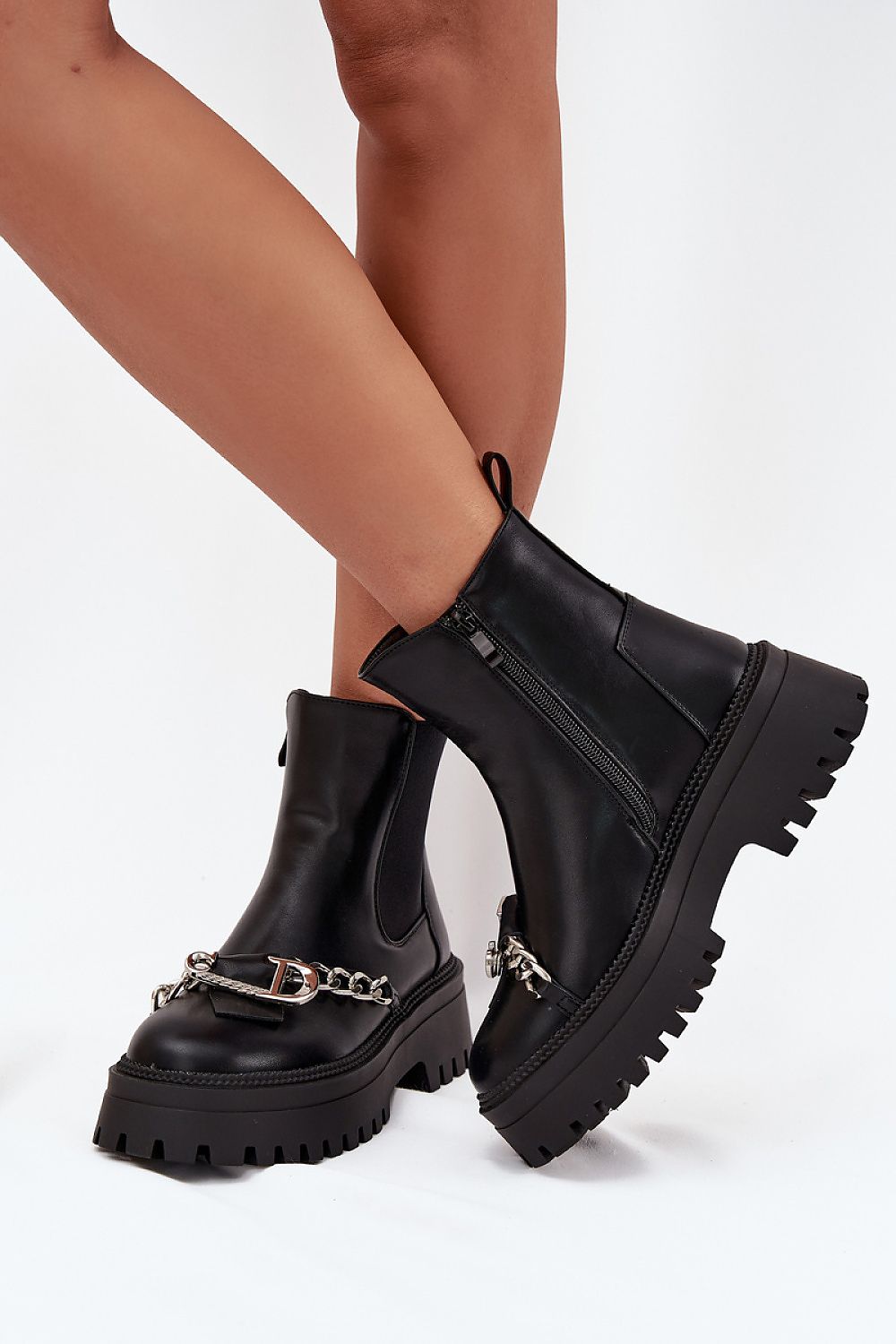 Side view of stylish women’s eco leather ankle boots featuring buckle and chain details on the shaft, with zipper closure.