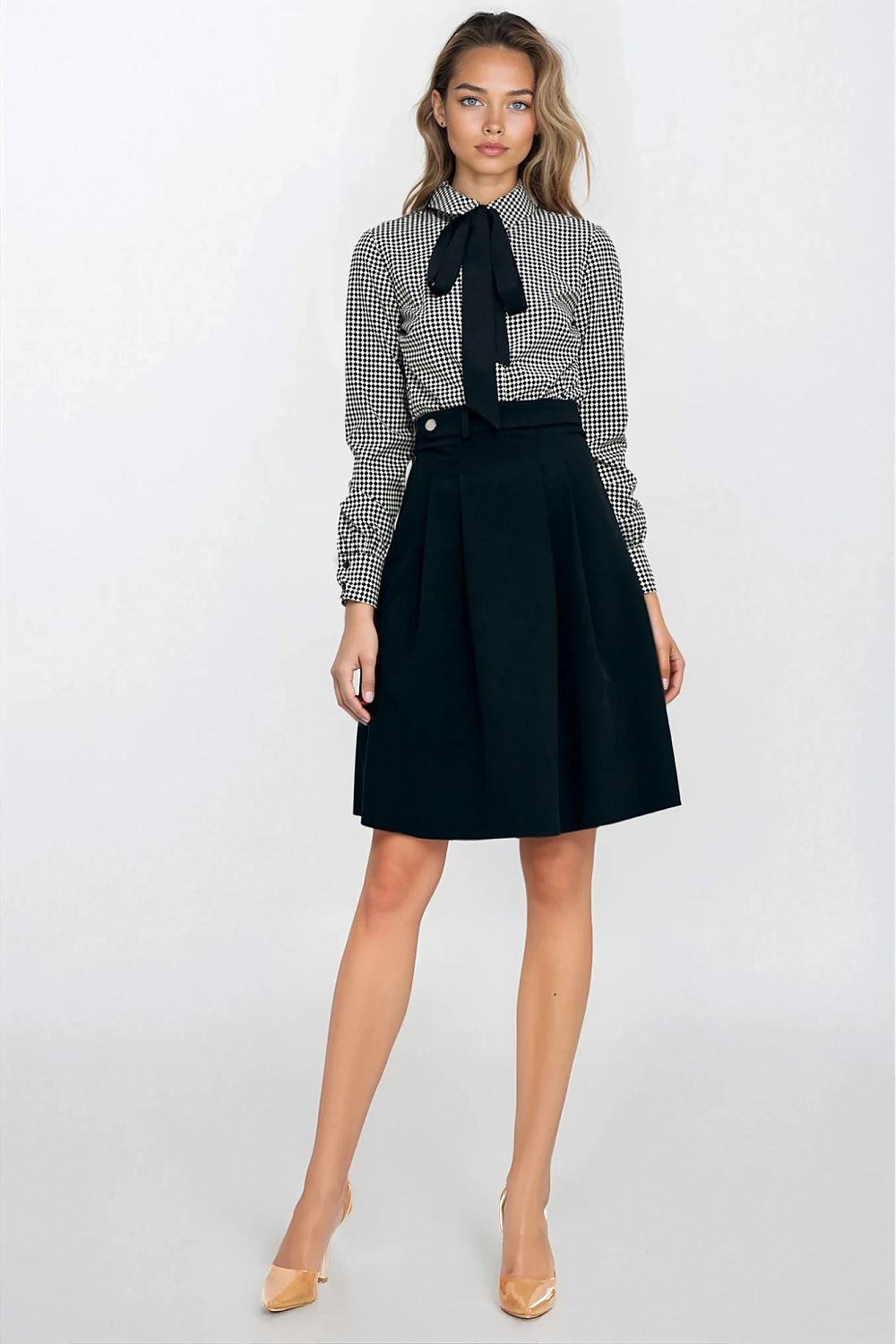 Woman wearing a checkered shirt with a black bow tie and black skirt on a white background