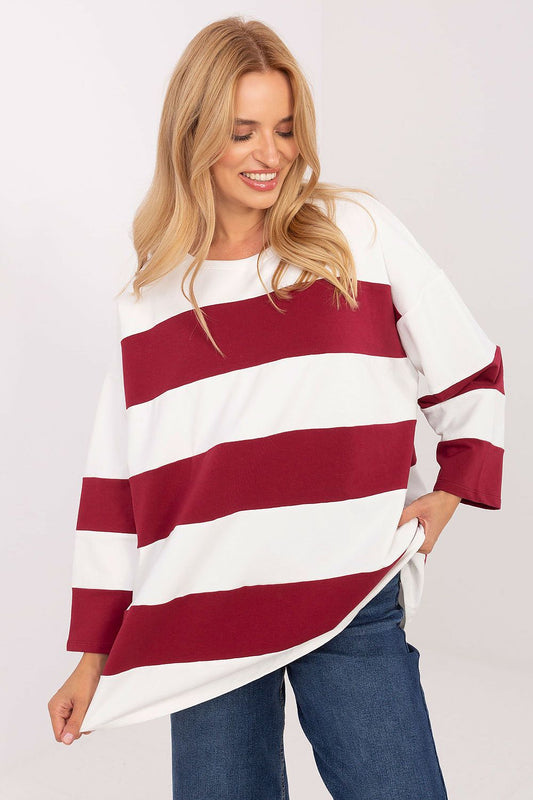Woman wearing a red and white striped sweater on a plain background