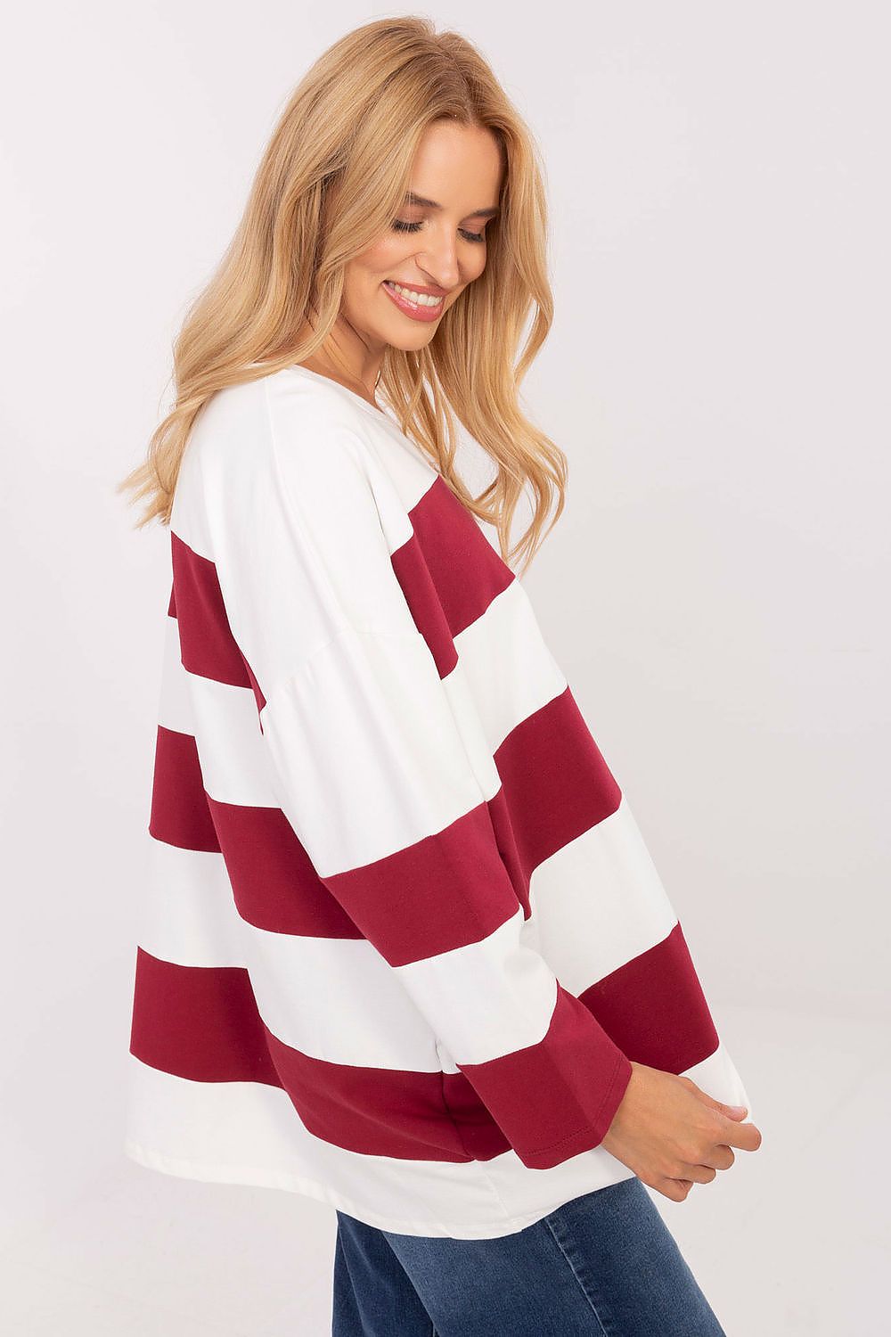Woman wearing a red and white striped sweater on a plain background