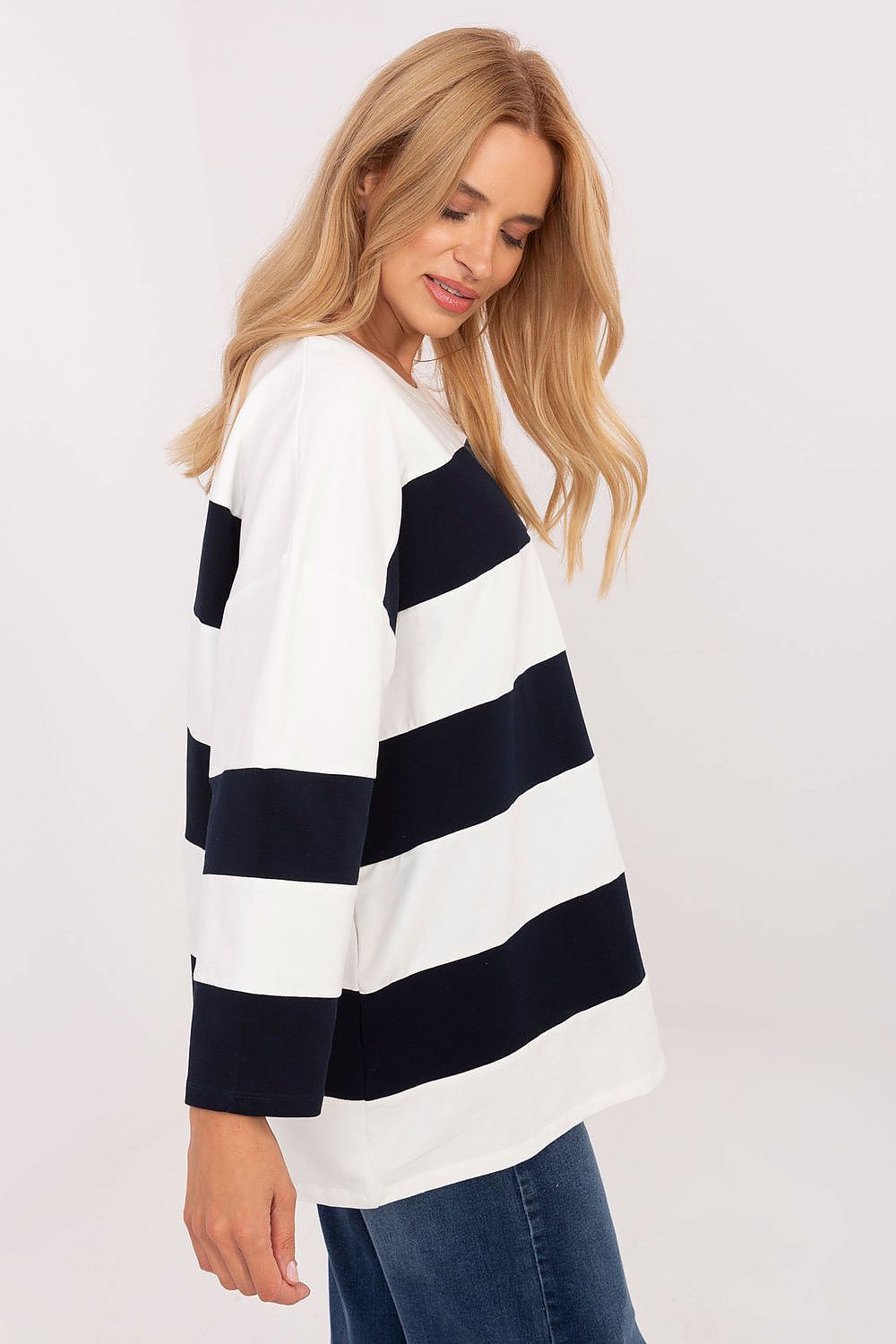 Woman wearing a white and navy striped sweater on a white background