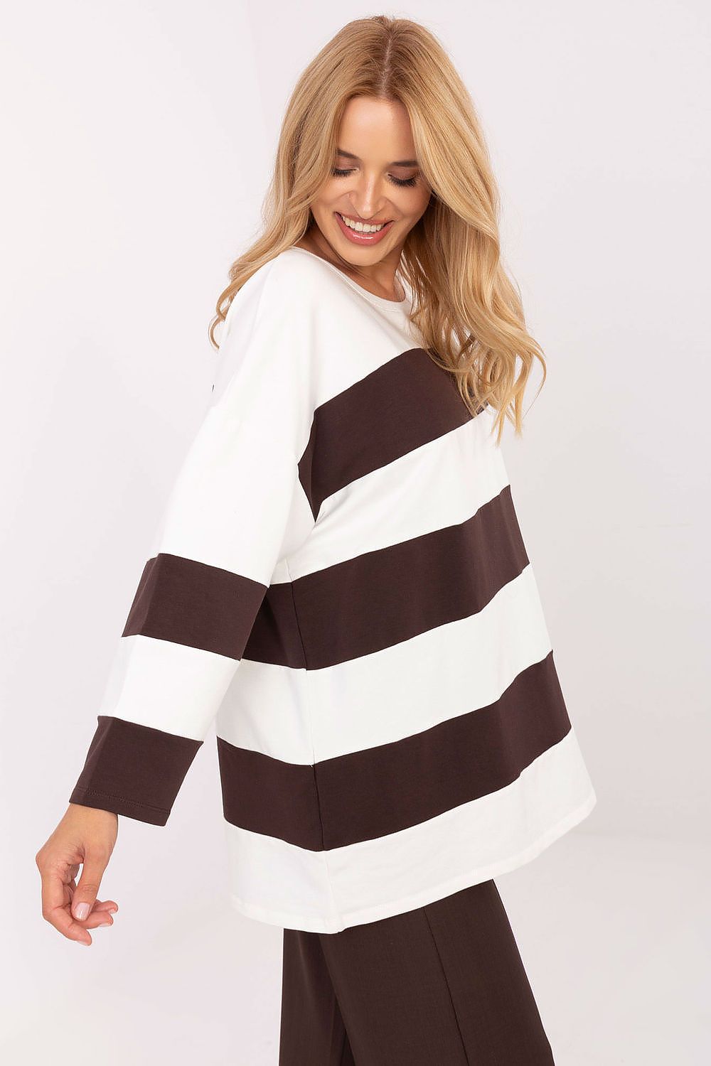 Woman wearing a white and brown striped sweater on a white background