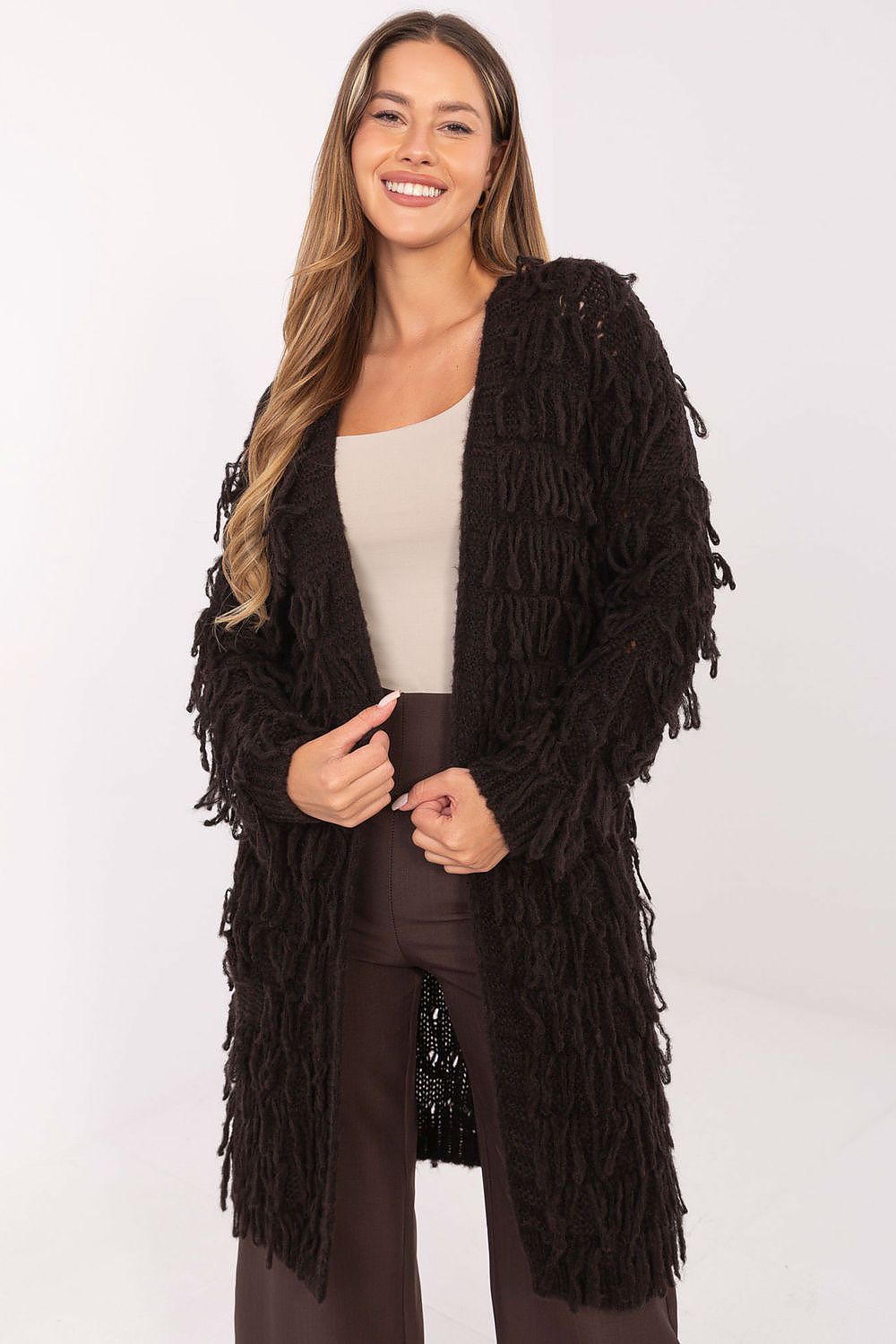 Woman wearing a long black fringed cardigan on a white background