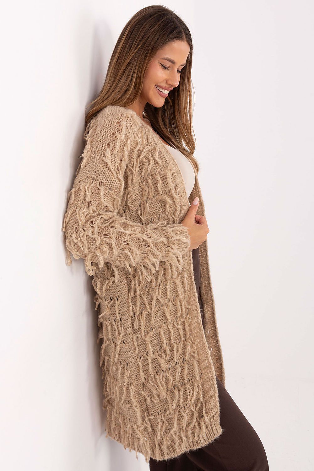 Side profile of beige open-front cardigan showing fringed texture.