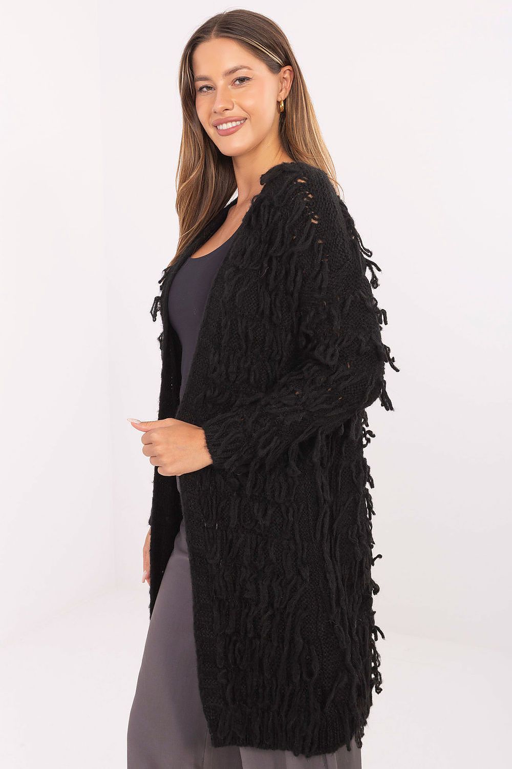 Side view of black fringed cardigan showing casual longline cut.