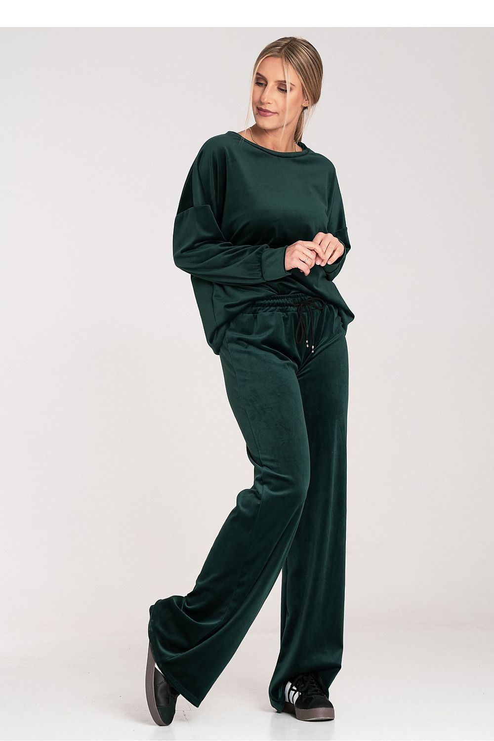 Woman wearing a green tracksuit on a white background