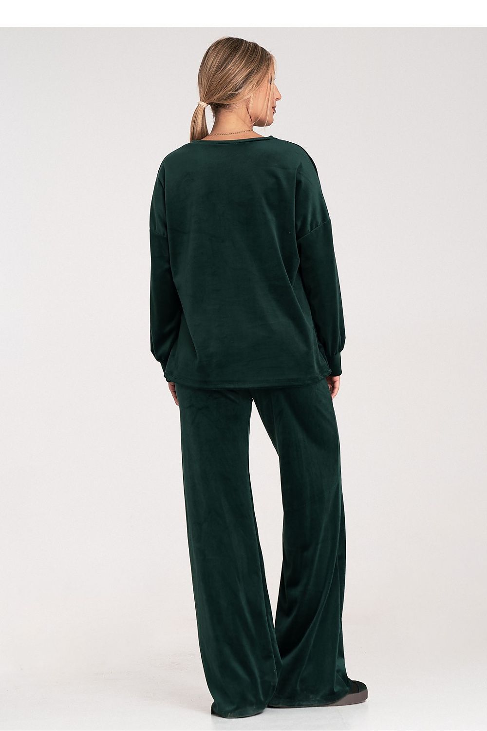 Person wearing a dark green lounge set on a white background