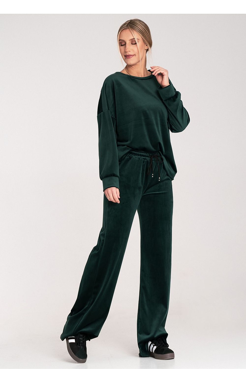Woman wearing a green tracksuit on a white background