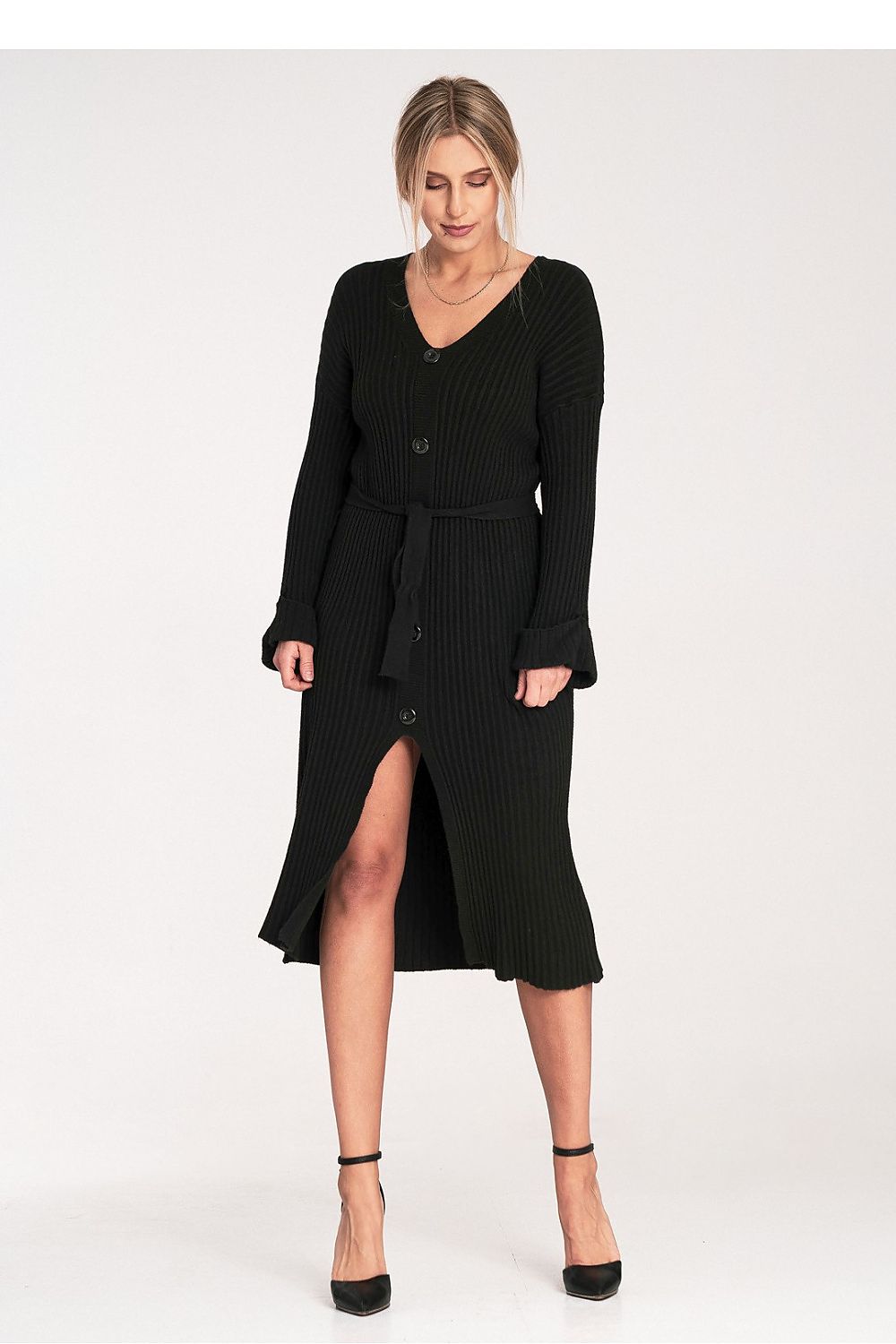 Woman wearing a black ribbed dress with a belt on a white background