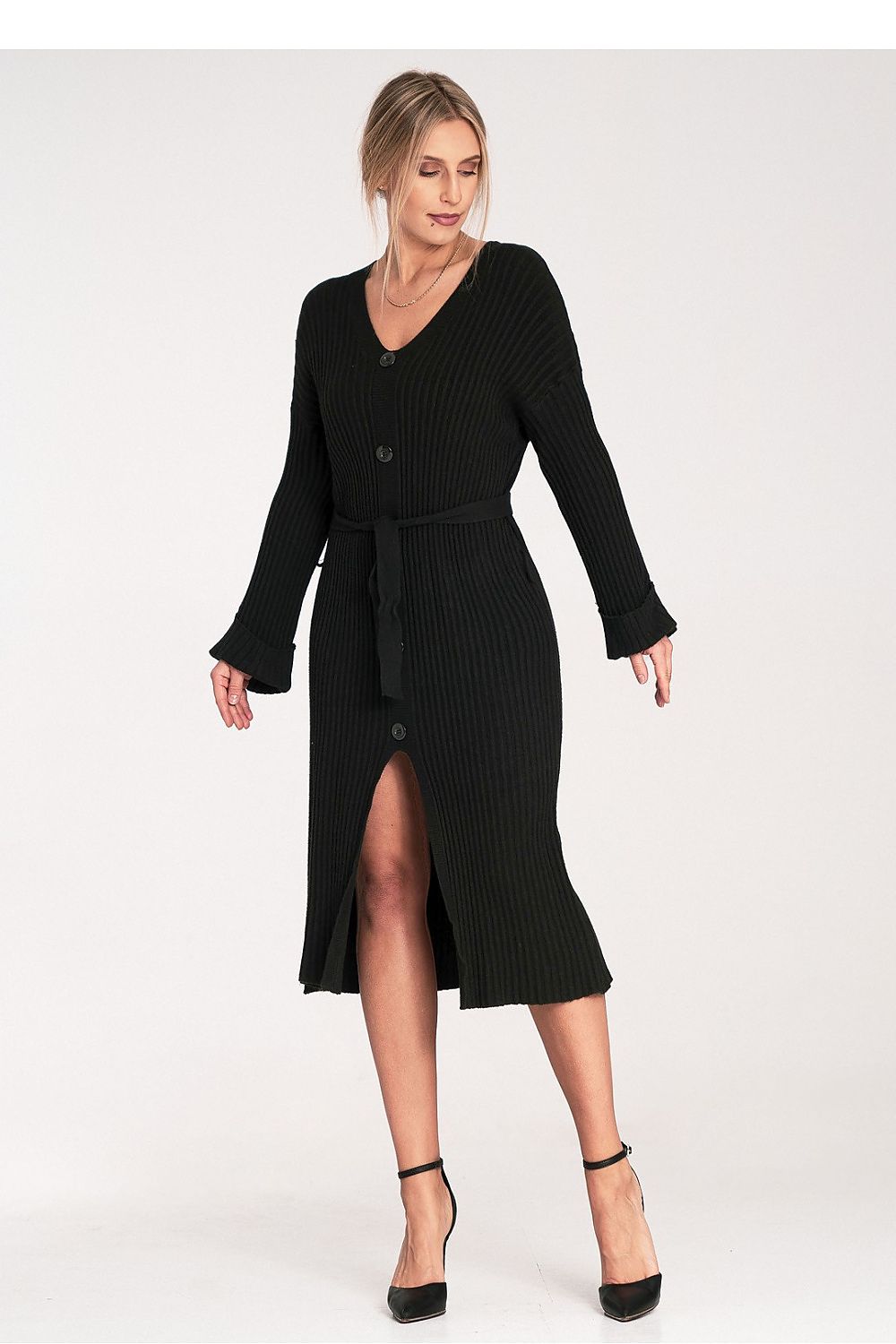 Woman wearing a black ribbed dress with a belt on a white background