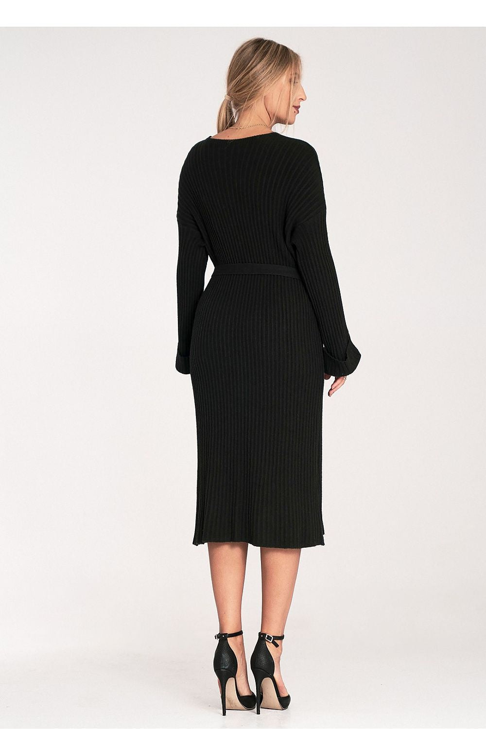 Woman wearing a black ribbed dress on a white background